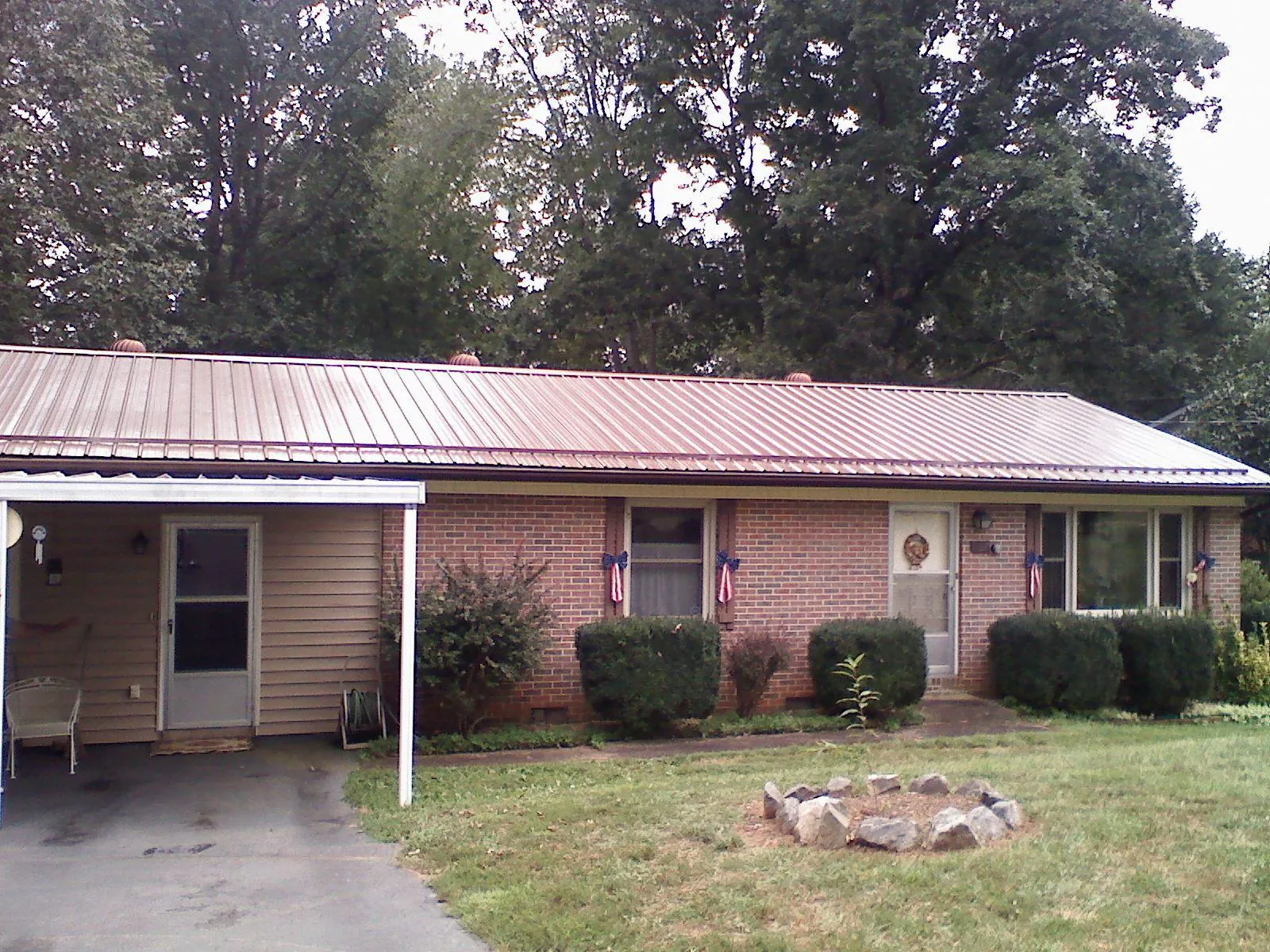 Bronze metal roof and carport on a brick ranch home — Roof Repair work by our crew in Pacolet